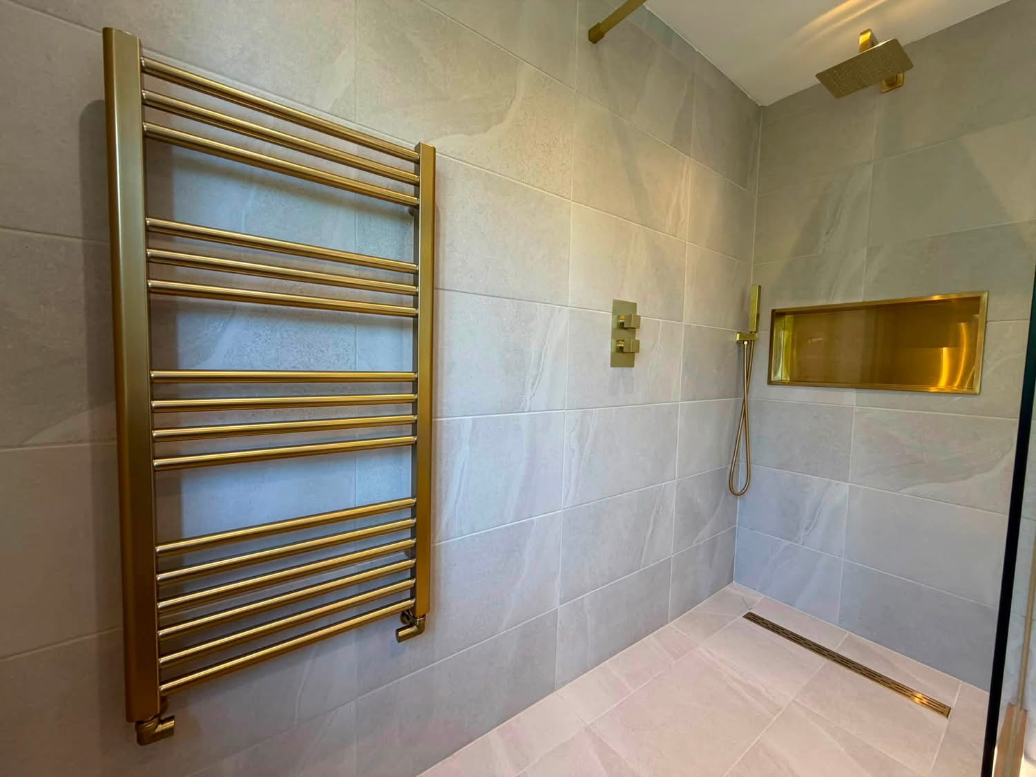 Walk-in shower with brushed gold towel rail